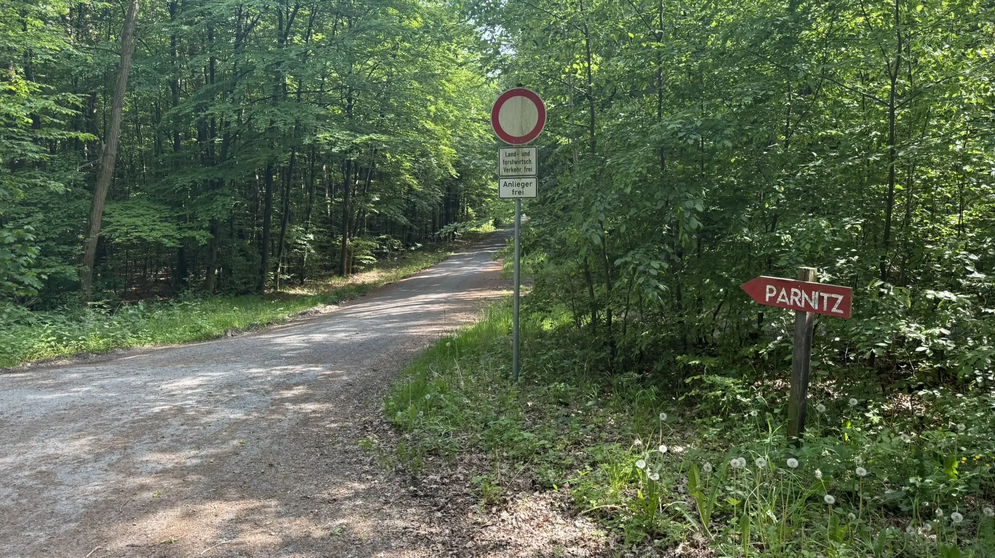 Einfahrt zum Waldweg mit rotem Parnitz-Wegweiser